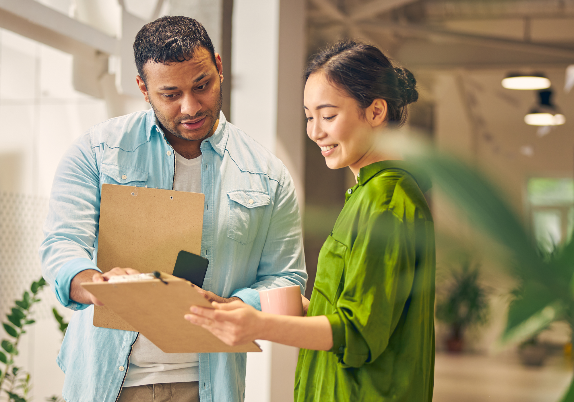 man showing woman a clipboard